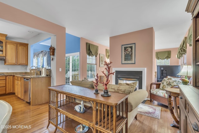 dining room featuring light wood-style flooring and a multi sided fireplace