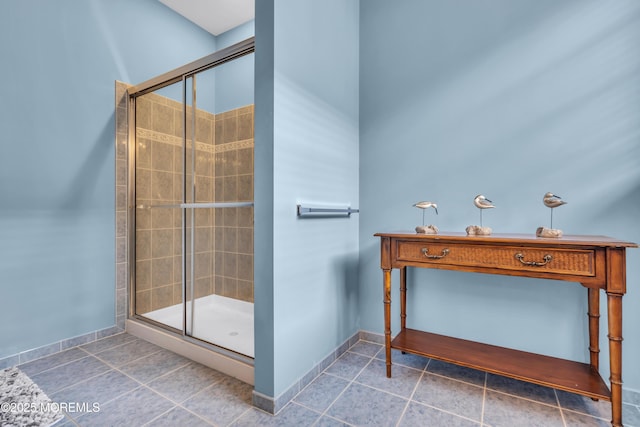 full bathroom featuring baseboards, a shower stall, and tile patterned flooring