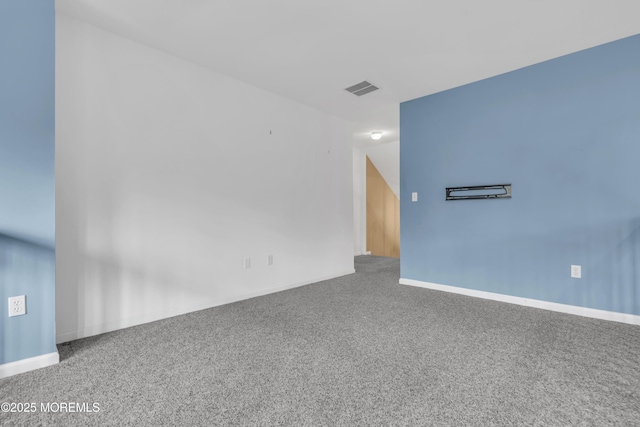 spare room featuring carpet, visible vents, and baseboards