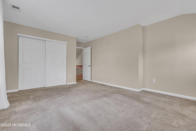 unfurnished bedroom with a closet, visible vents, baseboards, and carpet floors