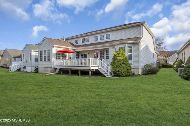 rear view of property featuring a deck and a lawn