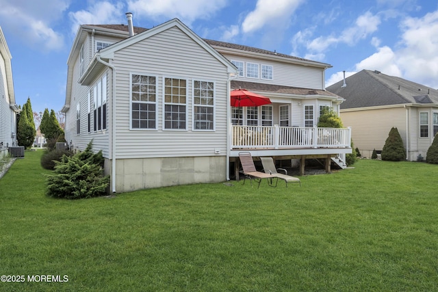 back of property with central AC, a deck, and a yard