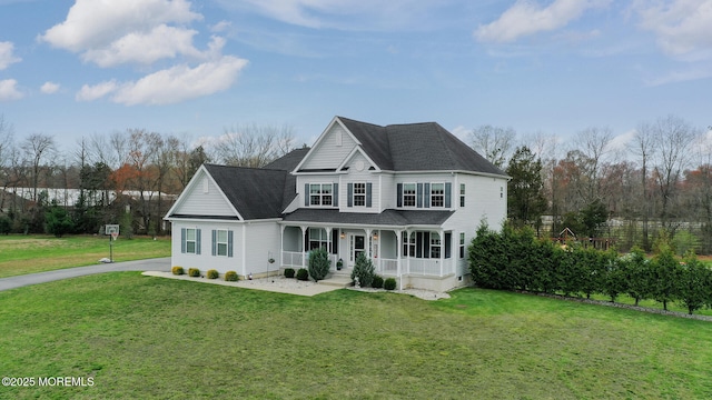 traditional-style home with a front lawn, driveway, and covered porch