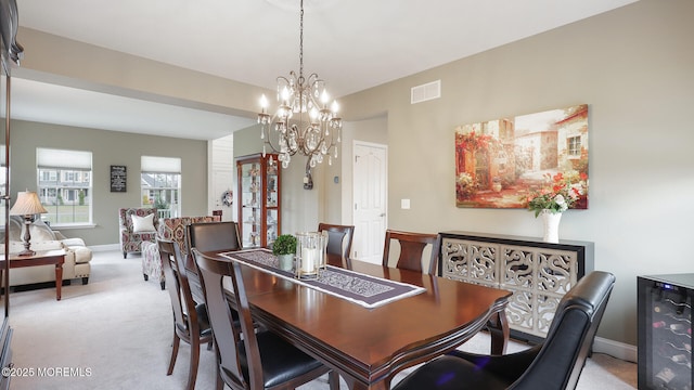 dining area with baseboards, visible vents, light colored carpet, and an inviting chandelier