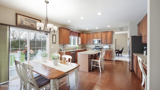 kitchen featuring a chandelier, brown cabinetry, a kitchen island, and stainless steel appliances