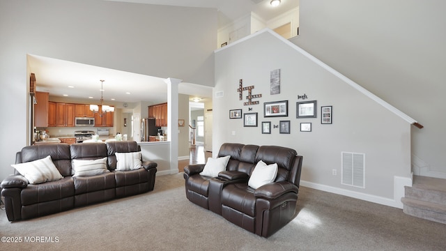 carpeted living room with baseboards, recessed lighting, visible vents, a towering ceiling, and a chandelier