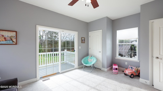 doorway to outside featuring ceiling fan, carpet floors, visible vents, and baseboards