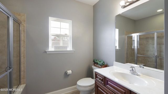 full bath featuring a shower stall, baseboards, toilet, and vanity