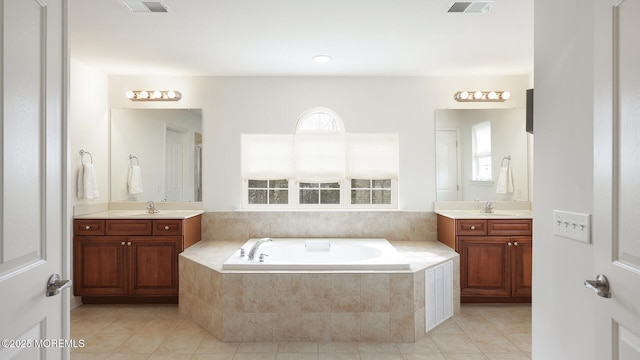 bathroom featuring a garden tub, tile patterned floors, visible vents, and a wealth of natural light