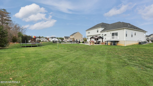 view of yard with a gazebo, a trampoline, and central AC unit