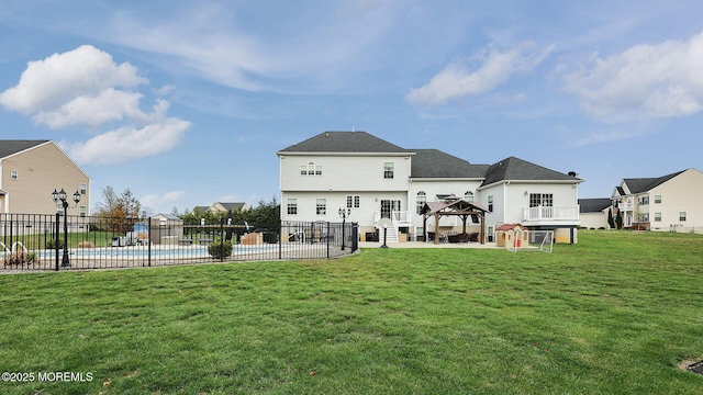 rear view of property with a gazebo, a fenced in pool, a patio, and fence