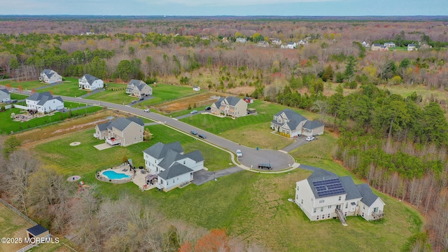 drone / aerial view featuring a view of trees and a residential view