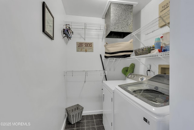 washroom featuring washer and dryer, baseboards, laundry area, and dark tile patterned flooring