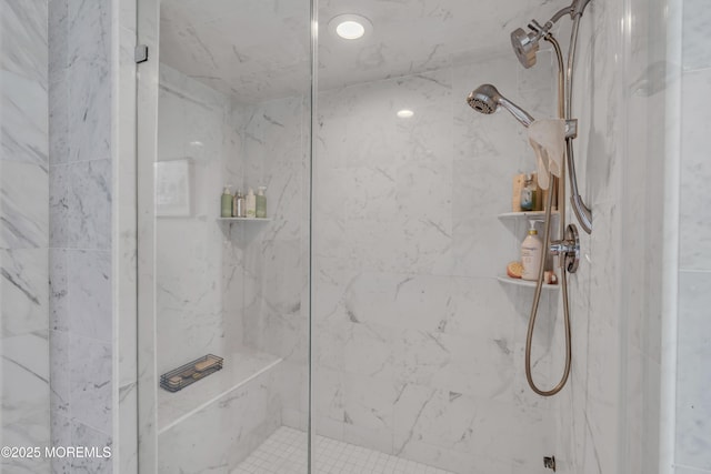 bathroom featuring a marble finish shower