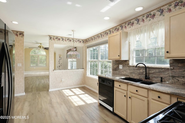 kitchen with light brown cabinetry, a sink, baseboards, light wood-type flooring, and black appliances
