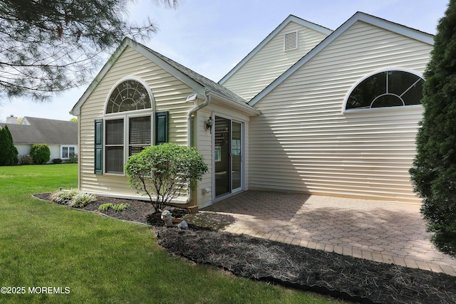 rear view of house featuring a yard and a patio