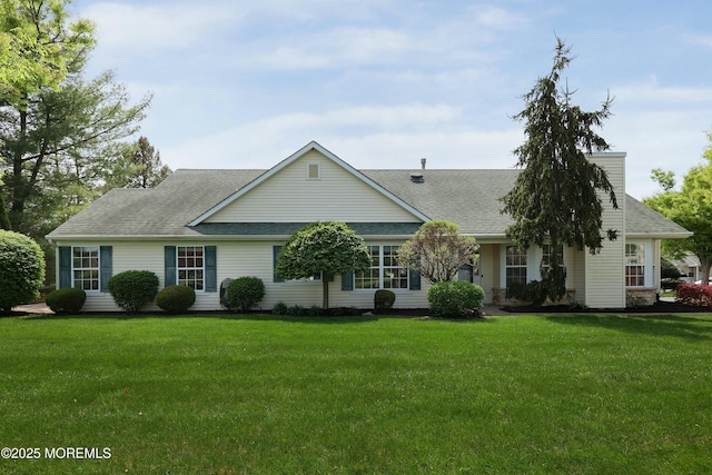 view of front of home with roof with shingles and a front yard