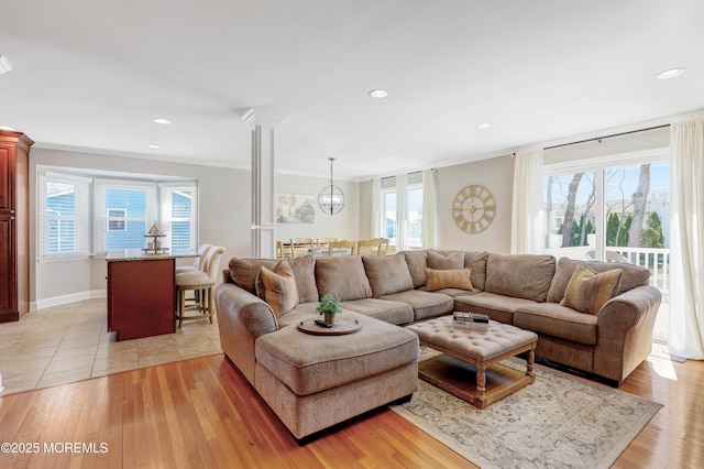 living area with plenty of natural light, light wood finished floors, and ornamental molding
