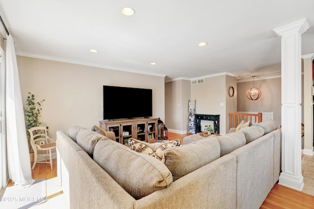 living area with recessed lighting, visible vents, light wood-style floors, baseboards, and decorative columns