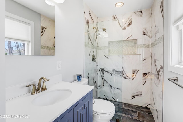 bathroom featuring toilet, vanity, a marble finish shower, and recessed lighting