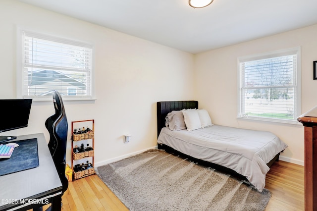bedroom with baseboards and wood finished floors
