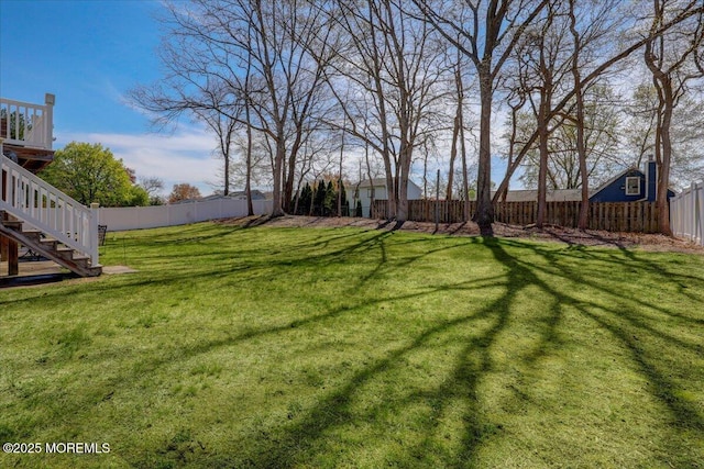 view of yard featuring a fenced backyard and stairs