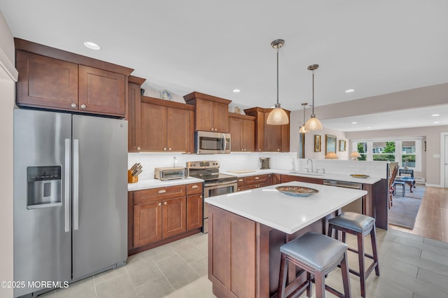 83 Parkway Dr Unit E, Freehold, NJ 07728 - kitchen featuring light countertops, appliances with stainless steel finishes, backsplash, and a peninsula