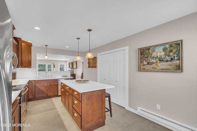 83 Parkway Dr Unit E, Freehold, NJ 07728 - kitchen featuring a sink, baseboard heating, stainless steel appliances, tasteful backsplash, and a kitchen bar