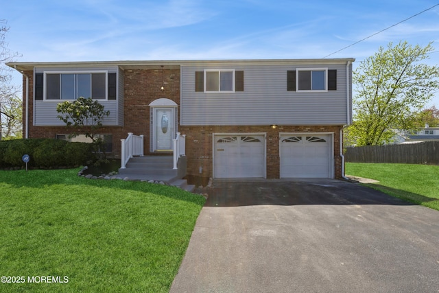 503 Mayfair Ln, Neptune Township, NJ 07753 - split foyer home with a front lawn, fence, brick siding, an attached garage, and driveway