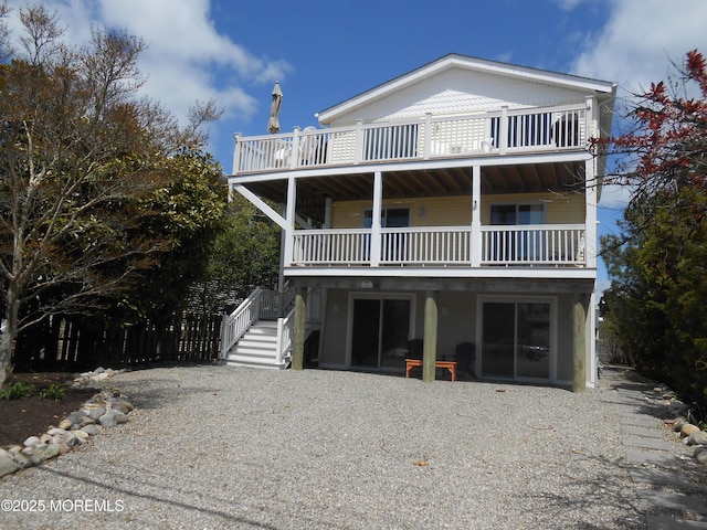 view of front of house with stairway and a balcony