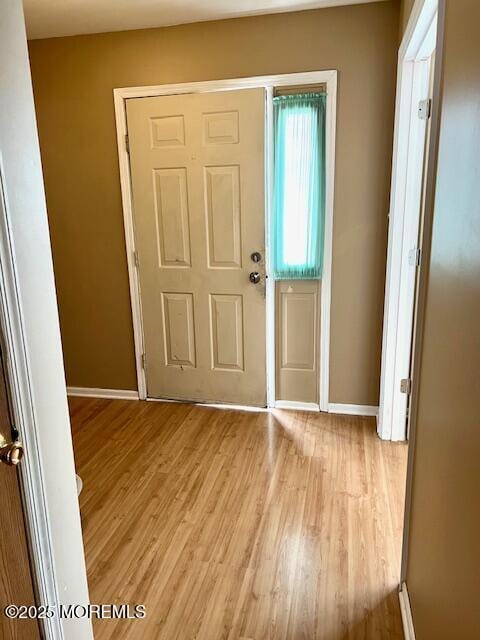 foyer featuring light wood finished floors and baseboards