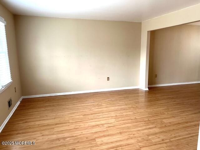 spare room featuring light wood-style flooring and baseboards
