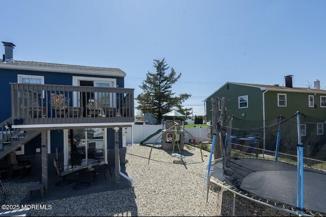 3124 Stanley Dr, Toms River, NJ 08753 - back of property featuring a trampoline, a fenced backyard, stairway, and a wooden deck