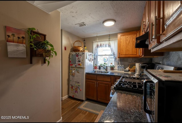 3124 Stanley Dr, Toms River, NJ 08753 - kitchen with freestanding refrigerator, extractor fan, a sink, brown cabinets, and wood finished floors
