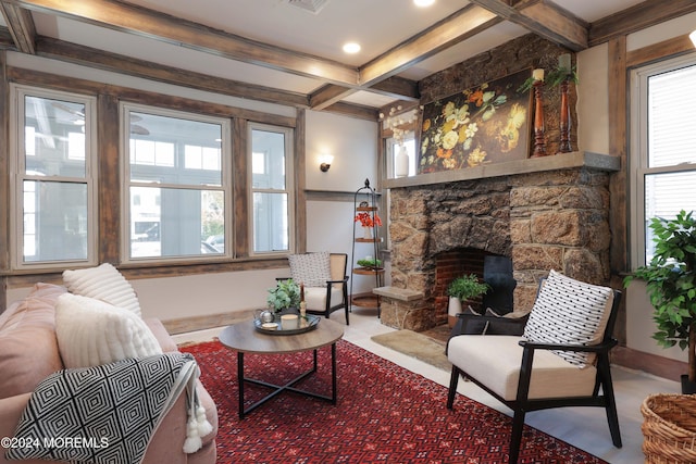 living area featuring a stone fireplace, beam ceiling, baseboards, and coffered ceiling
