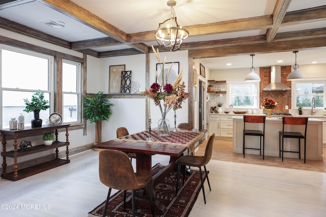 dining area with beam ceiling, visible vents, light wood-style floors, a chandelier, and coffered ceiling