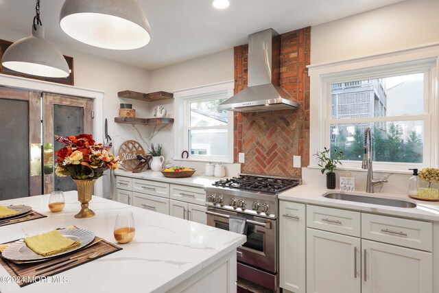 kitchen with white cabinets, light stone counters, open shelves, wall chimney range hood, and high end stainless steel range oven