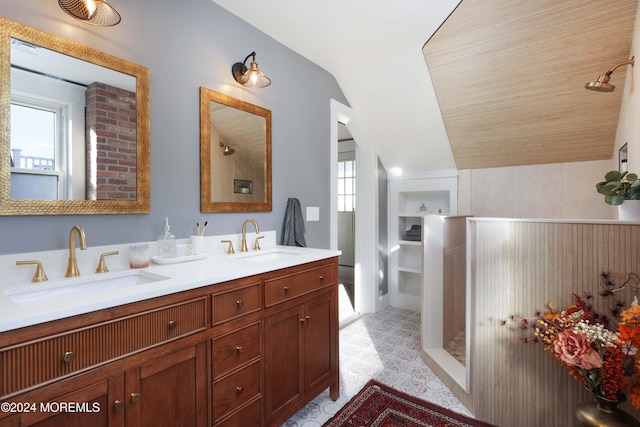 full bath featuring a shower, lofted ceiling, a sink, and double vanity