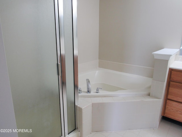 bathroom with a bath, a stall shower, vanity, and tile patterned flooring