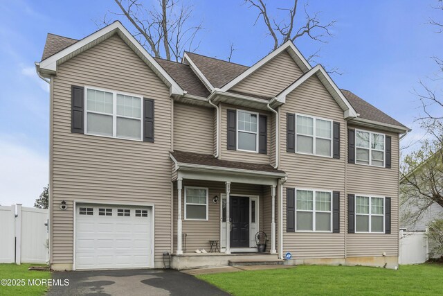 89 Orchard St, Freehold, NJ 07728 - view of front of home featuring roof with shingles, driveway, an attached garage, a front lawn, and fence