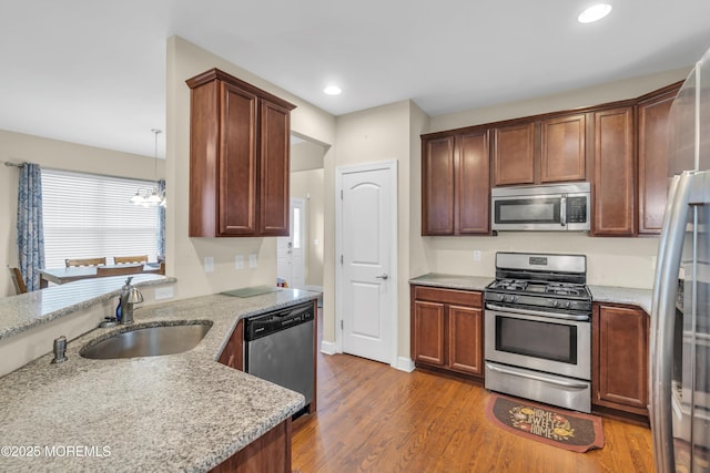 89 Orchard St, Freehold, NJ 07728 - kitchen featuring stainless steel appliances, light stone countertops, a sink, and dark wood finished floors