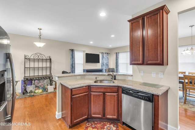 89 Orchard St, Freehold, NJ 07728 - kitchen featuring a peninsula, appliances with stainless steel finishes, a sink, hanging light fixtures, and light wood finished floors