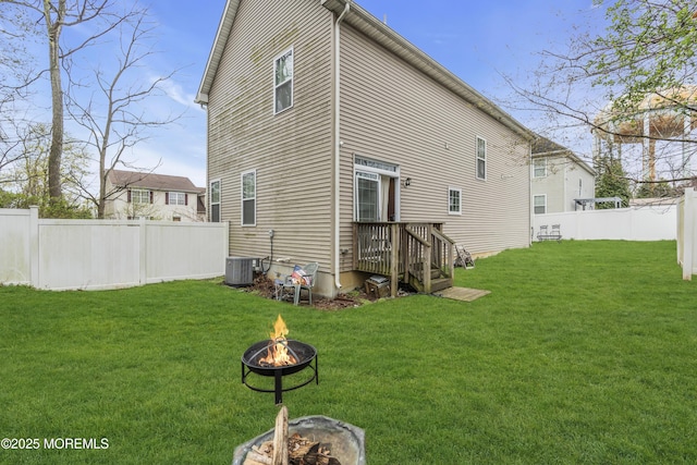 89 Orchard St, Freehold, NJ 07728 - back of house with a fire pit, central air condition unit, fence, and a lawn