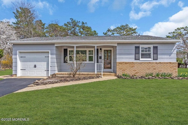 single story home with an attached garage, driveway, brick siding, and a front yard