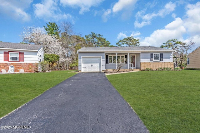 view of front of house with brick siding, an attached garage, a front lawn, and driveway