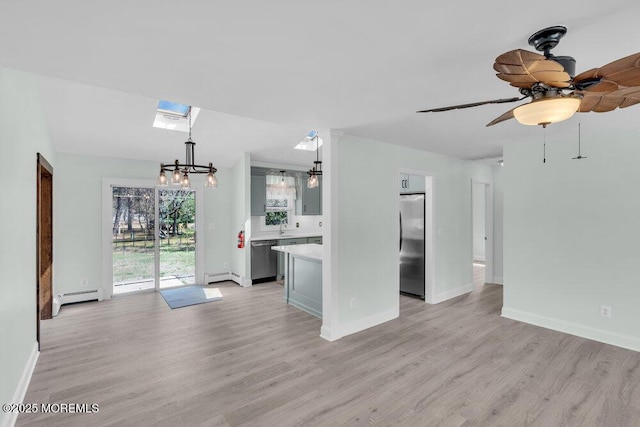 unfurnished living room with a baseboard heating unit and light wood-type flooring