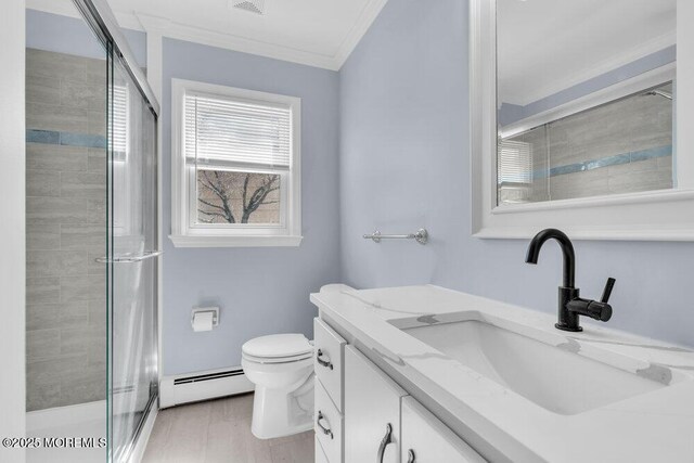 full bathroom featuring a shower stall, toilet, vanity, crown molding, and baseboard heating
