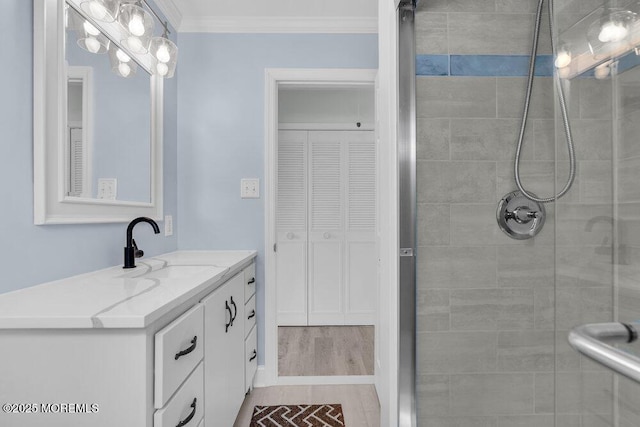 full bathroom with crown molding, vanity, and tiled shower