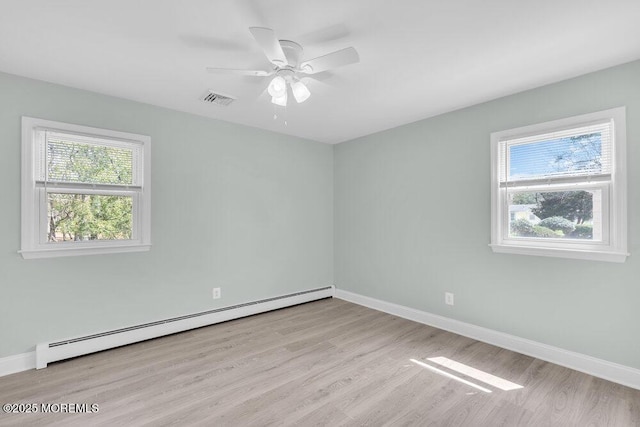 spare room featuring baseboard heating, baseboards, a ceiling fan, and wood finished floors