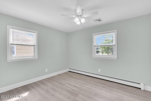 spare room with wood finished floors, visible vents, a ceiling fan, baseboards, and baseboard heating